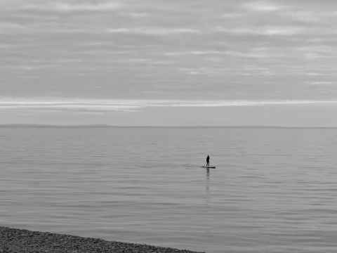 Lone paddleboarder on a calm channel